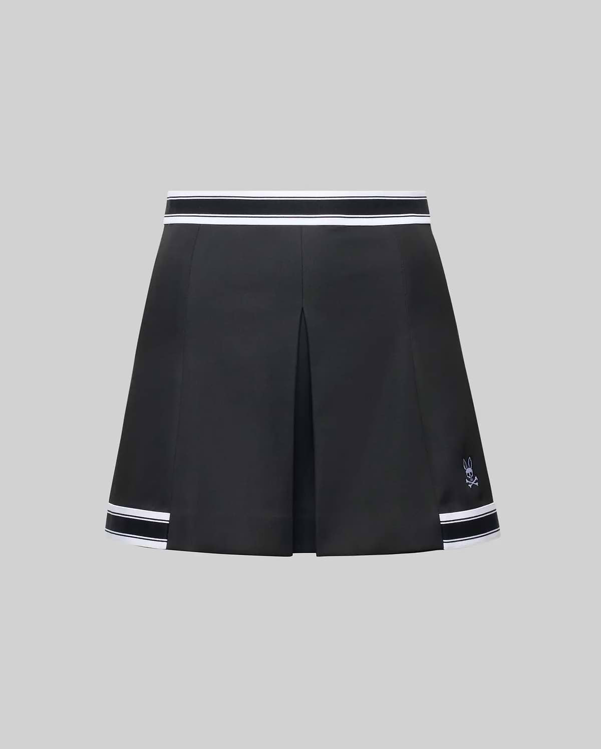 The WOMENS KNIT SKORT - WO1900001 by Psycho Bunny is a black pleated mini skort with white striped trim at the waistband and hem, plus a small white Psycho Bunny logo near the left hem, shown on a plain gray background. (6)