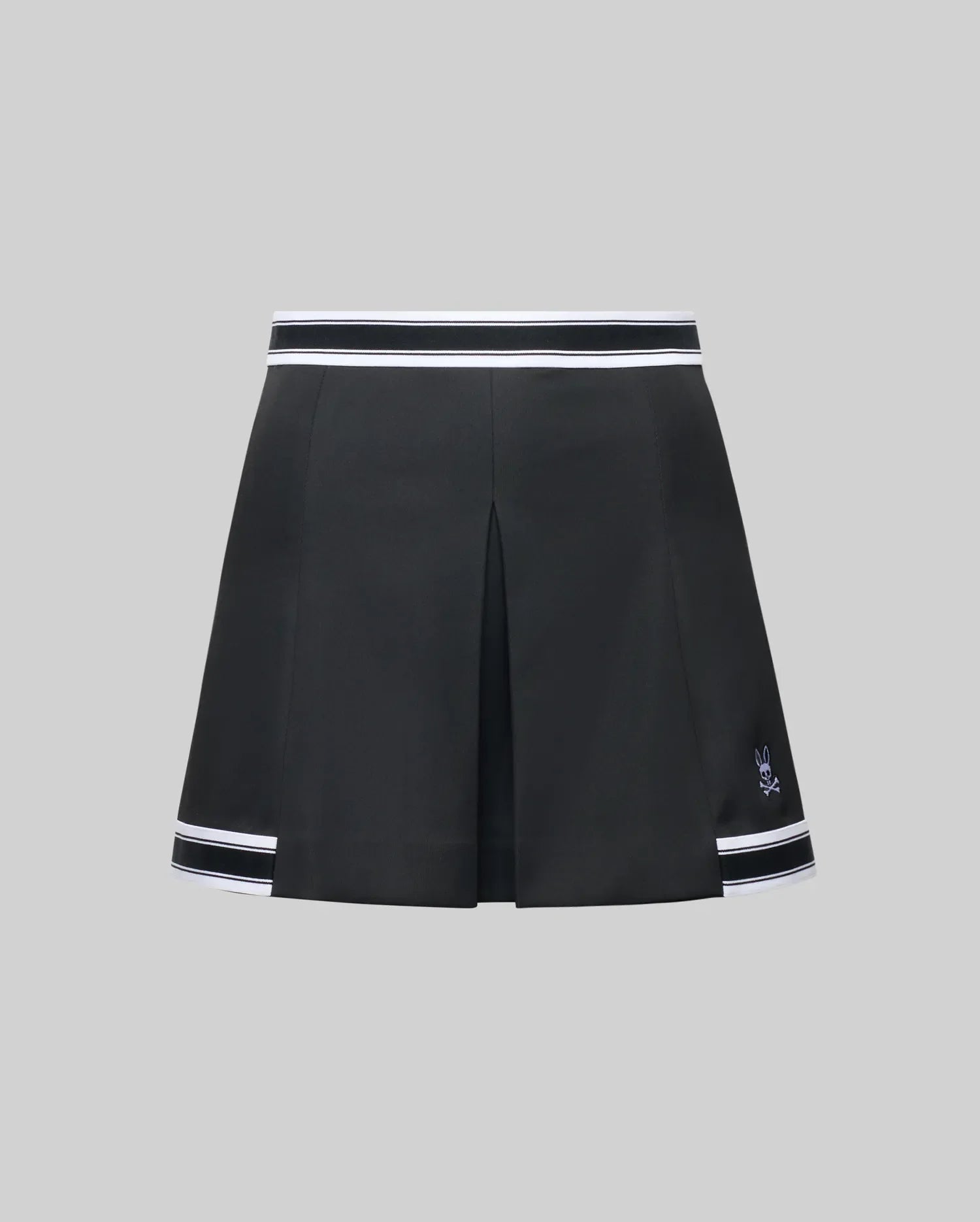 The WOMENS KNIT SKORT - WO1900001 by Psycho Bunny is a black pleated mini skort with white striped trim at the waistband and hem, plus a small white Psycho Bunny logo near the left hem, shown on a plain gray background. (6)