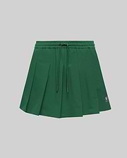 WOMEN'S CECILIA PLEATED SKORT in dark green, featuring an elastic drawstring waist, a relaxed A-line fit with crisp pleats, and a small embroidered pink Psycho Bunny skull logo on the lower right hem. (5)