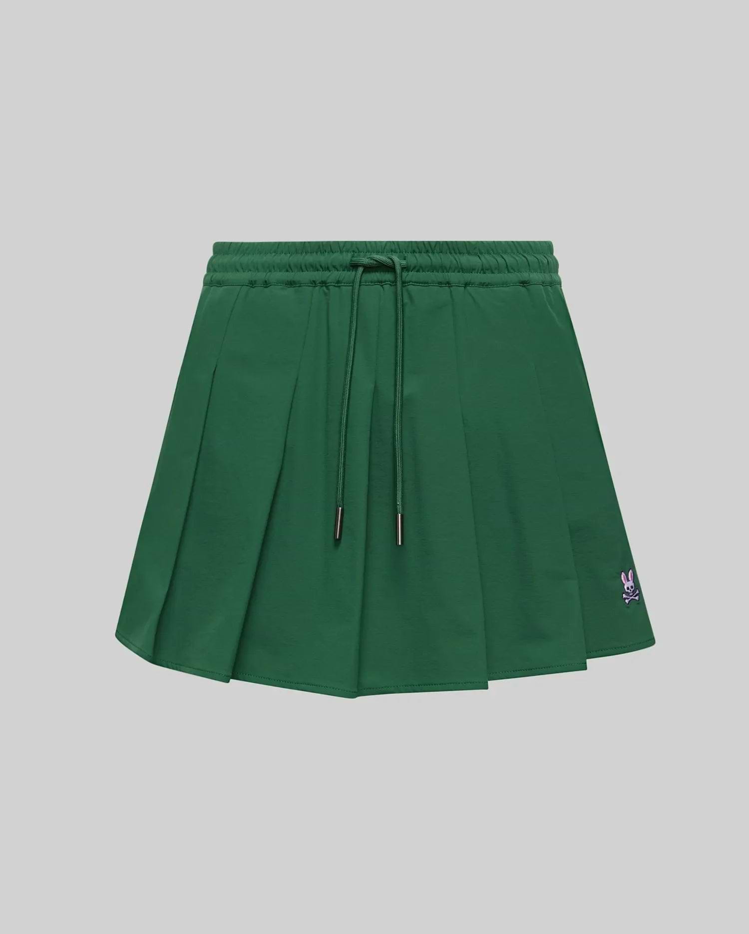 WOMEN'S CECILIA PLEATED SKORT in dark green, featuring an elastic drawstring waist, a relaxed A-line fit with crisp pleats, and a small embroidered pink Psycho Bunny skull logo on the lower right hem. (5)