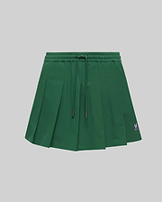 WOMEN'S CECILIA PLEATED SKORT in dark green, featuring an elastic drawstring waist, a relaxed A-line fit with crisp pleats, and a small embroidered pink Psycho Bunny skull logo on the lower right hem. (5)
