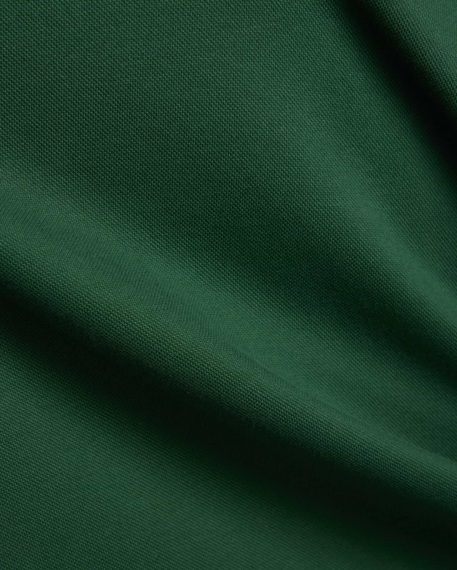 Women's Clara Pique Dress, a luxurious deep forest green garment, featuring a finely woven, breathable pique fabric texture with elegant, soft drapes and subtle shadows, reflecting premium quality. (6)