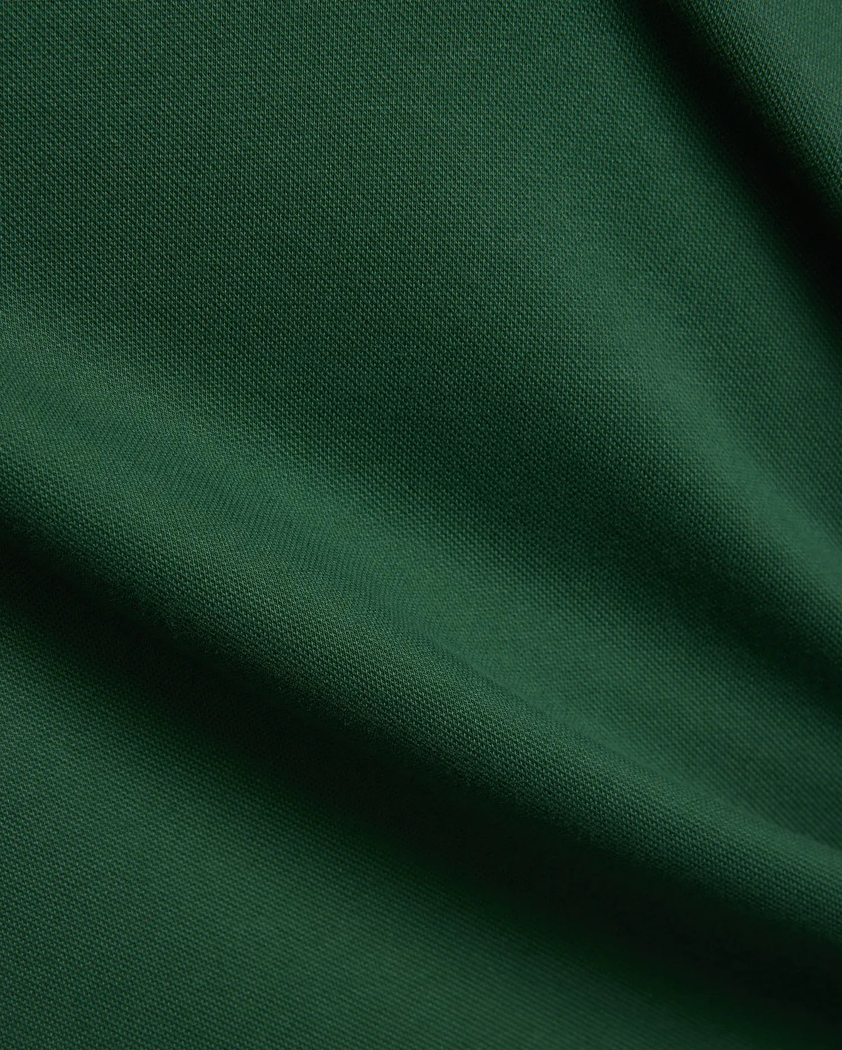 Women's Clara Pique Dress, a luxurious deep forest green garment, featuring a finely woven, breathable pique fabric texture with elegant, soft drapes and subtle shadows, reflecting premium quality. (6)