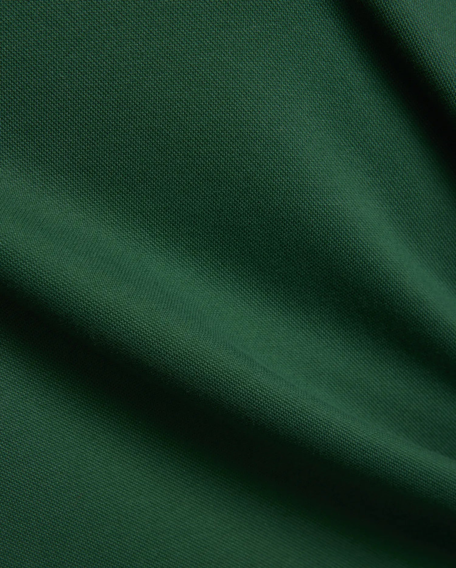 Women's Clara Pique Dress, a luxurious deep forest green garment, featuring a finely woven, breathable pique fabric texture with elegant, soft drapes and subtle shadows, reflecting premium quality. (6)