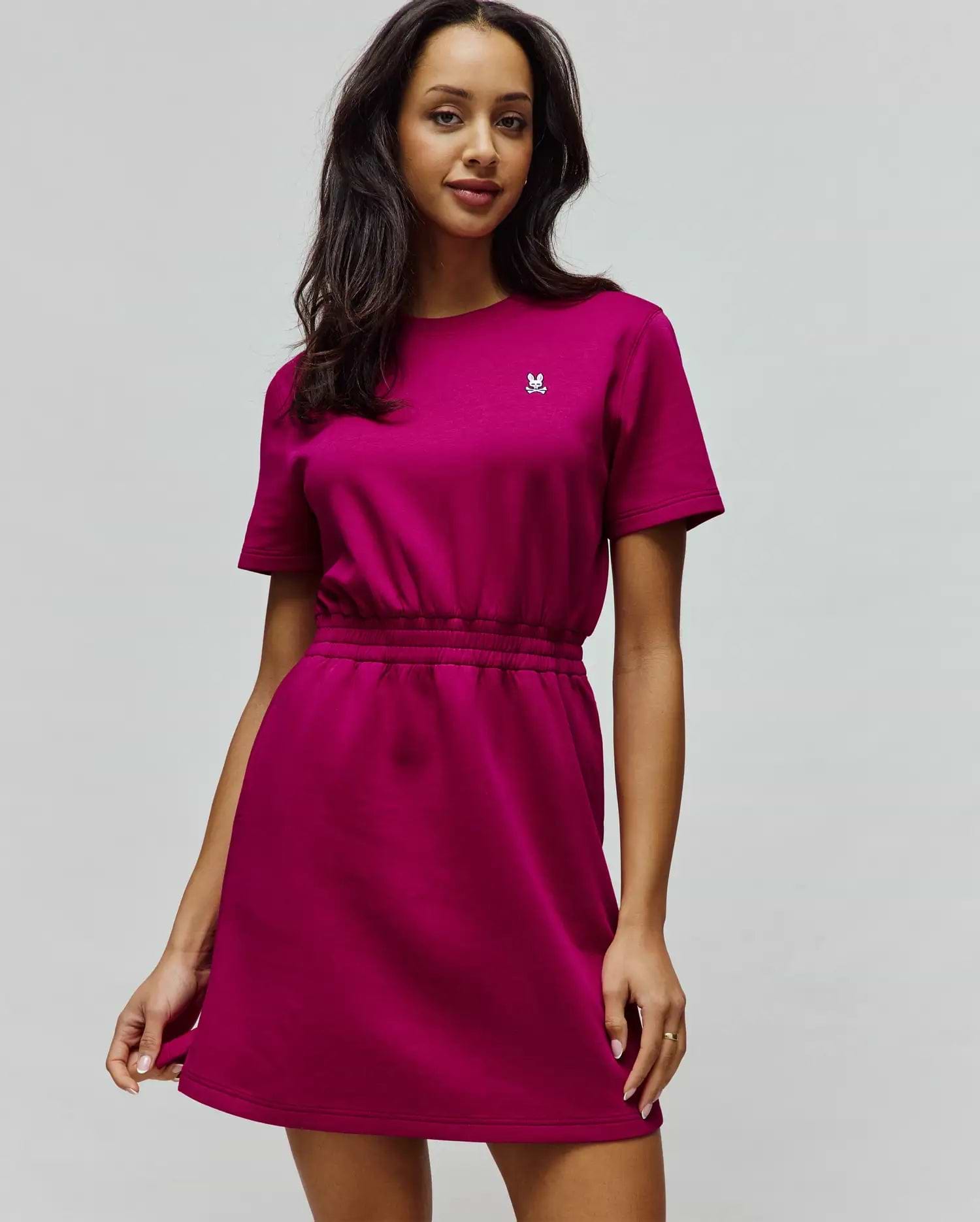 Womens Penelope Dress in vibrant magenta jersey, featuring a relaxed fit, short sleeves, elasticated waist, and a small embroidered white Psycho Bunny skull logo on the left chest. (4)
