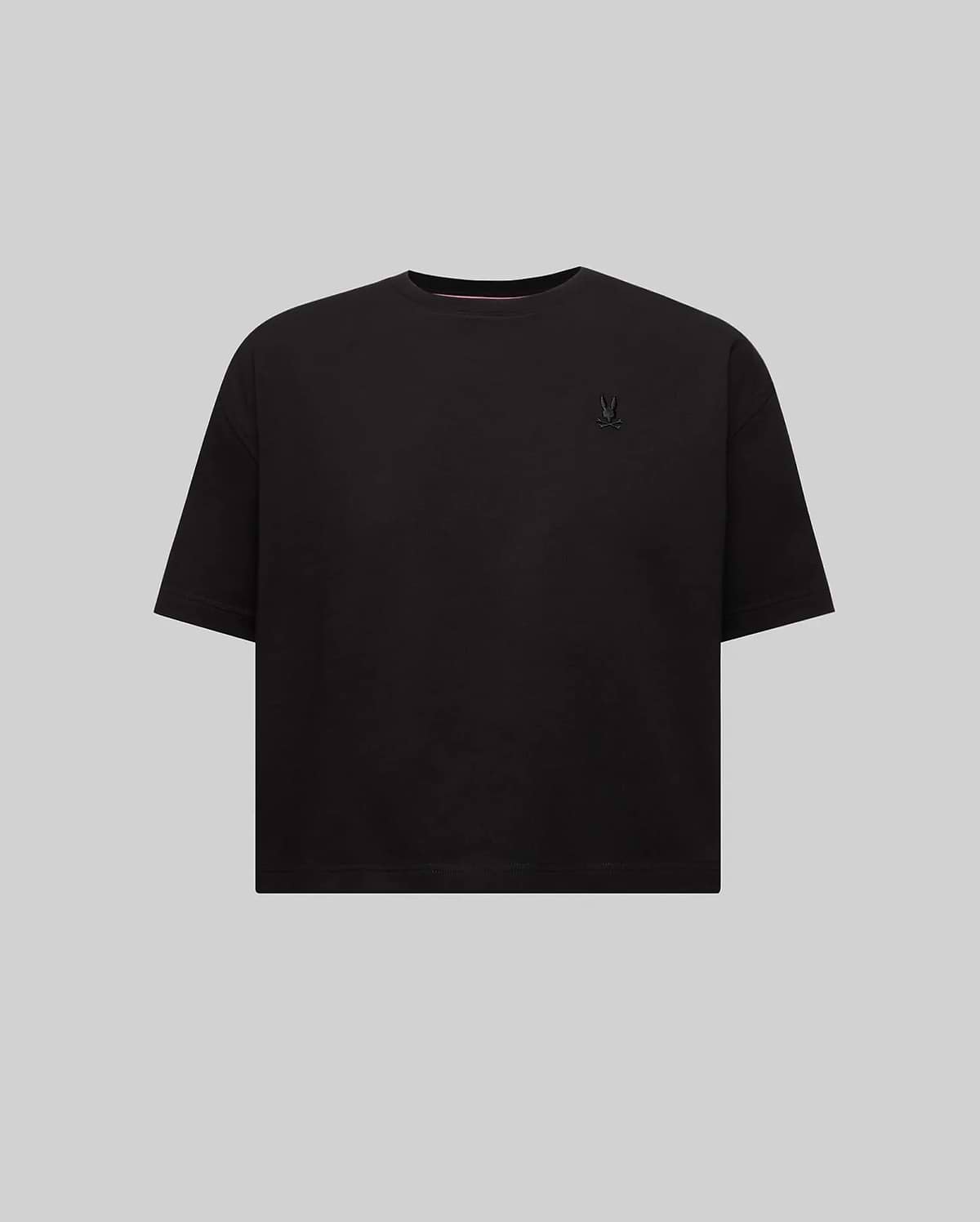 Women's Camille Oversized Fit Tee in black jersey, featuring a small, tone-on-tone embroidered Psycho Bunny skull logo on the left chest and a subtle pink inner collar stripe.