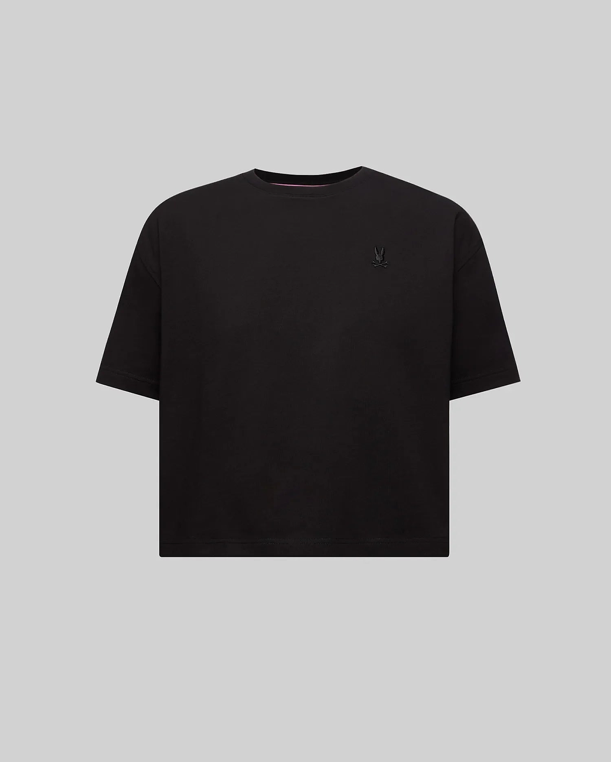 Women's Camille Oversized Fit Tee in black jersey, featuring a small, tone-on-tone embroidered Psycho Bunny skull logo on the left chest and a subtle pink inner collar stripe.