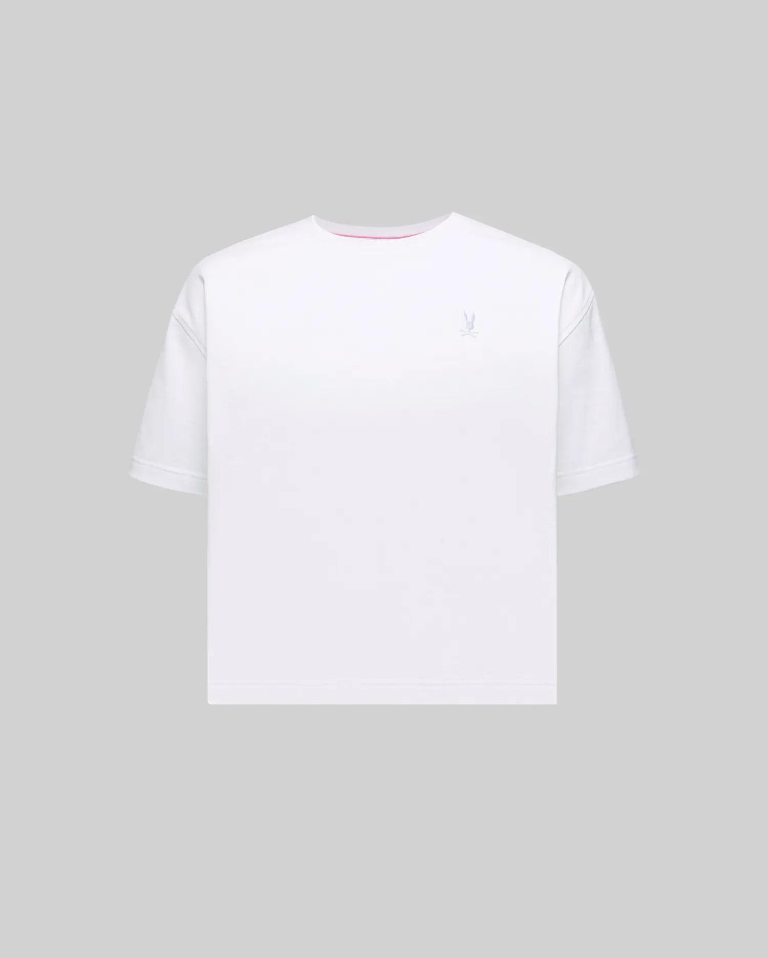 Women's Camille Oversized Fit Tee in white jersey knit, featuring a small embroidered light blue Psycho Bunny skull logo on the left chest and a subtle pink accent trim inside the crew neckline.
