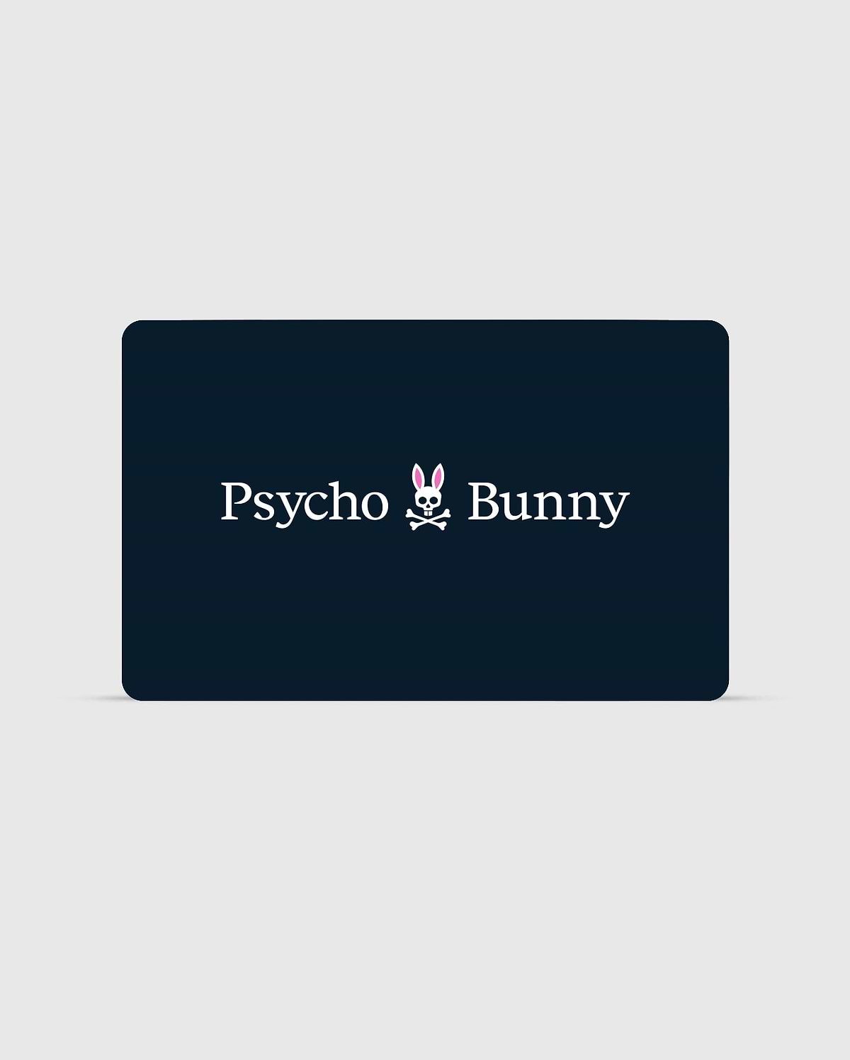 A rectangular card with a dark background features the text "Psycho Bunny Canada" in white. Between the words is a stylized logo of a bunny head with pink ears and a skull and crossbones beneath it. You can check your balance or redeem your Digital Gift Card for exclusive Psycho Bunny apparel using their digital platform. (1)
