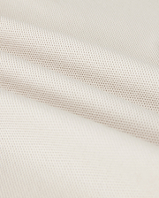A close-up shows the Psycho Bunny MENS CLASSIC PIQUE POLO SHIRT - B6K001B200, with a textured weave pattern. The soft white fabric resembles fine Pima cotton, with subtle shadowing in the folds that exude timeless men's fashion.