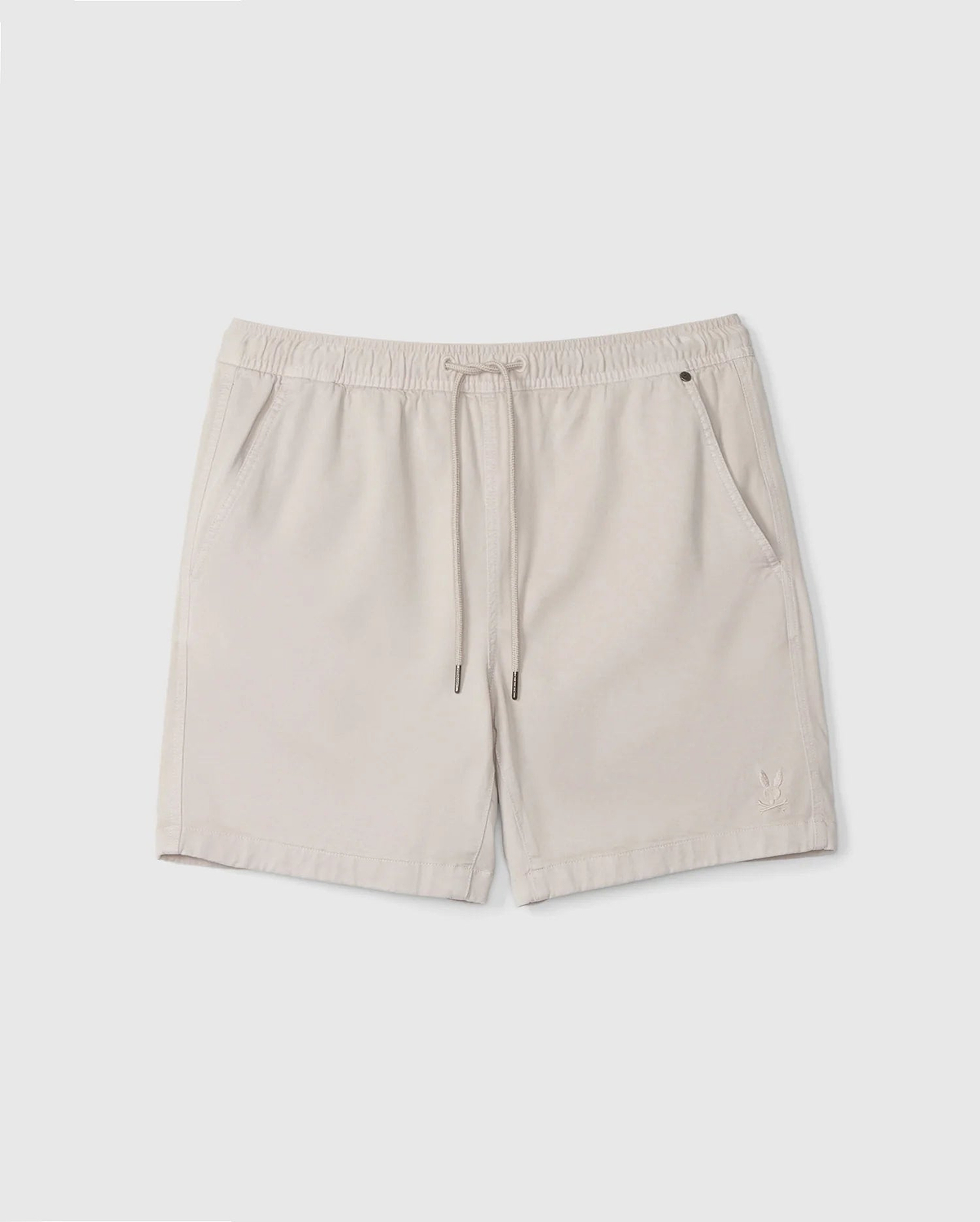 A pair of beige Men's Willis Stretch TENCEL™ shorts from Psycho Bunny, featuring an elastic waistband with a drawstring, two front pockets, and a small embroidered logo on the lower left. The lightweight fabric makes them ideal for casual wear.