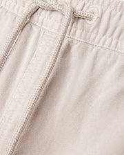 Close-up of the light beige Psycho Bunny MENS WILLIS STRETCH TENCEL SHORT - B6R239Y1WB, featuring an elasticated waistband with a drawstring. The fabric texture and stitching details are clearly visible, exemplifying the perfect combination of style and comfort.