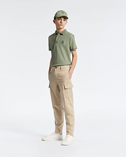 A teen boy in a green cap and polo with an embroidered logo wears Psycho Bunny's KIDS GREEN VALLEY CARGO PANT - B0P199E200 paired with white sneakers. The comfy fit and cargo pockets add to the casual, sporty vibe as he stands against a plain white background, gazing slightly to the side.
