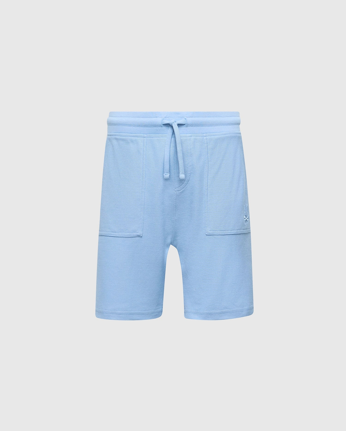The Psycho Bunny KIDS TAYLOR LIGHT PIQUE SWEATSHORT - B0R344F200 in light blue boasts a drawstring waistband, soft Pima cotton, two front pockets, and an embroidered bunny logo on the left side, offering a casual-chic design perfect for everyday wear.