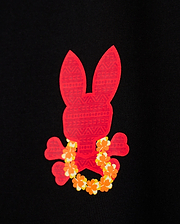 The KIDS HAWAII CITY TEE by Psycho Bunny features a red bunny skull and crossbones design surrounded by yellow and orange flowers, set against a black backdrop inspired by Hawaii's vibrant volcanic flora.