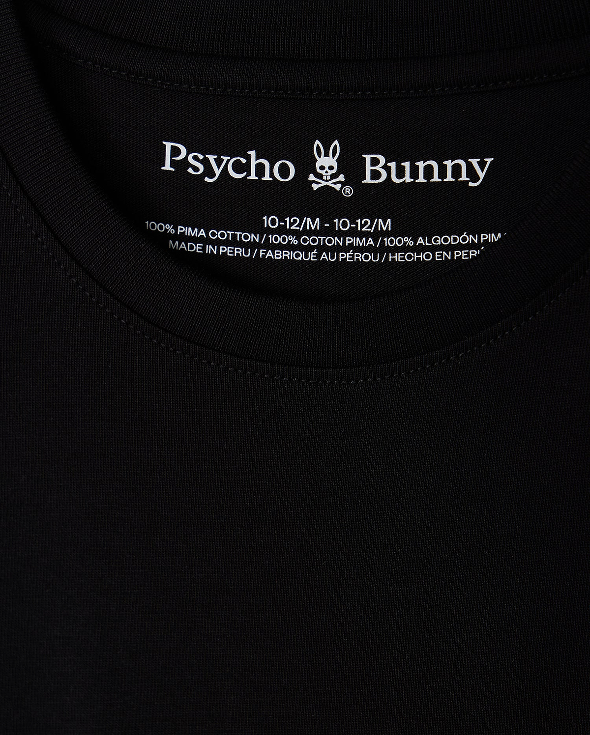 Close-up of the collar on the KIDS NEW YORK CITY TEE - B0U554W1PC in black, featuring the Psycho Bunny logo and text printed inside. This tee is crafted from 100% Pima cotton, ensuring exceptional softness and quality, and is proudly made in Peru.