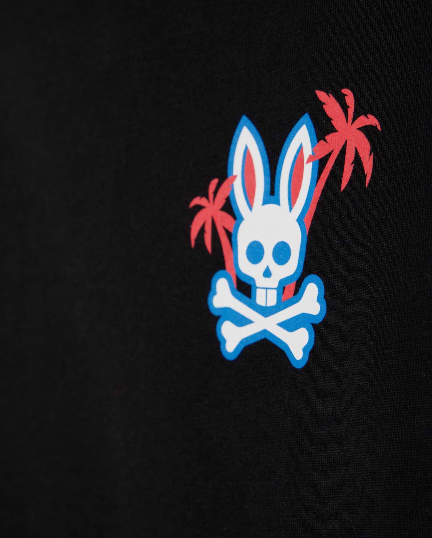 The KIDS LOS ANGELES CITY TEE - B0U861A2PC by Psycho Bunny showcases a bold graphic design featuring a white skull with bunny ears and crossbones on a black background. Two red palm trees stand behind the skull, enhanced by blue outline accents that add depth. Made from premium Peruvian Pima cotton, this tee combines style and comfort seamlessly.