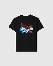 The KIDS LOS ANGELES CITY TEE - B0U861A2PC by Psycho Bunny features a luxurious Peruvian Pima cotton black T-shirt with "Los Angeles" boldly printed in white and blue font across the back. Above the text, decorative red line drawings of landmarks and symbols accompanied by "Psycho Bunny" add extra flair. Additionally, two small bunny logos embellish the bottom right corner.
