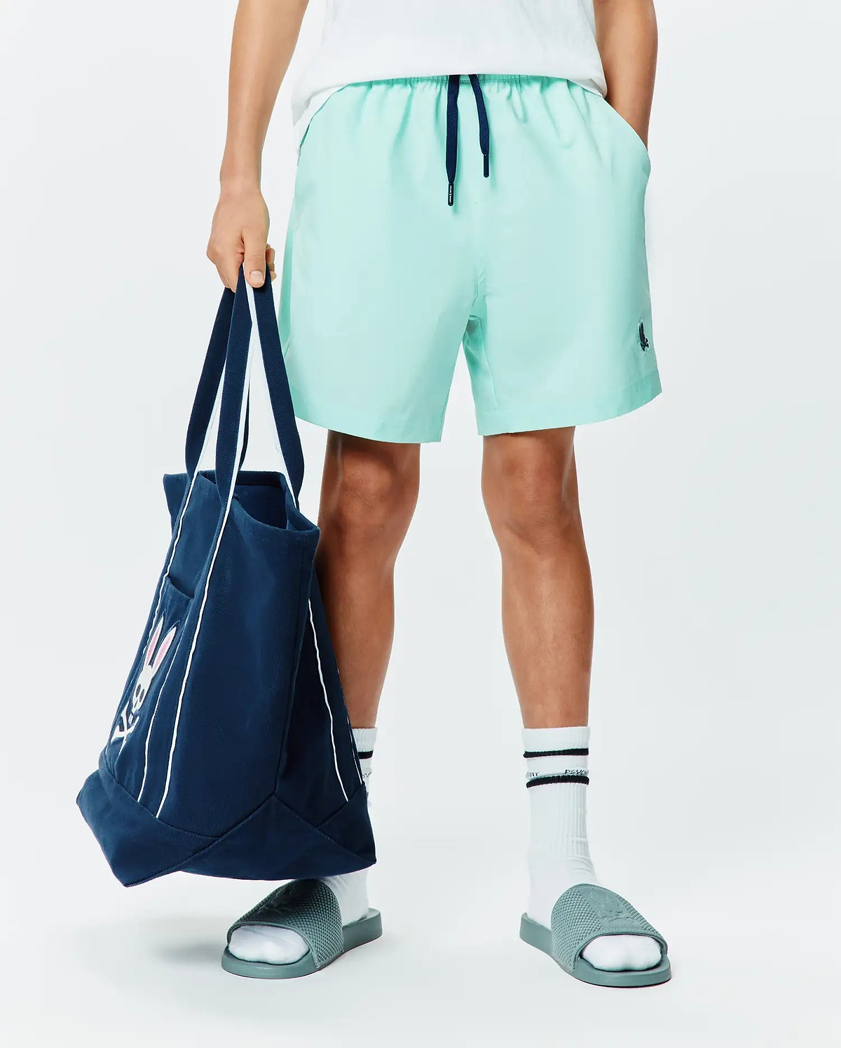 Kids Samos Hydrochromic Printed Swim Trunk in mint green, featuring a relaxed fit, smooth quick-dry fabric, navy drawstring, and a small embroidered Psycho Bunny skull logo on the left leg.