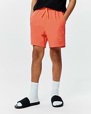 Kids Samos Hydrochromic Printed Swim Trunk in vibrant orange, featuring a relaxed fit, smooth quick-dry fabric, matching drawstring, and a small embroidered Psycho Bunny skull logo on the left leg.