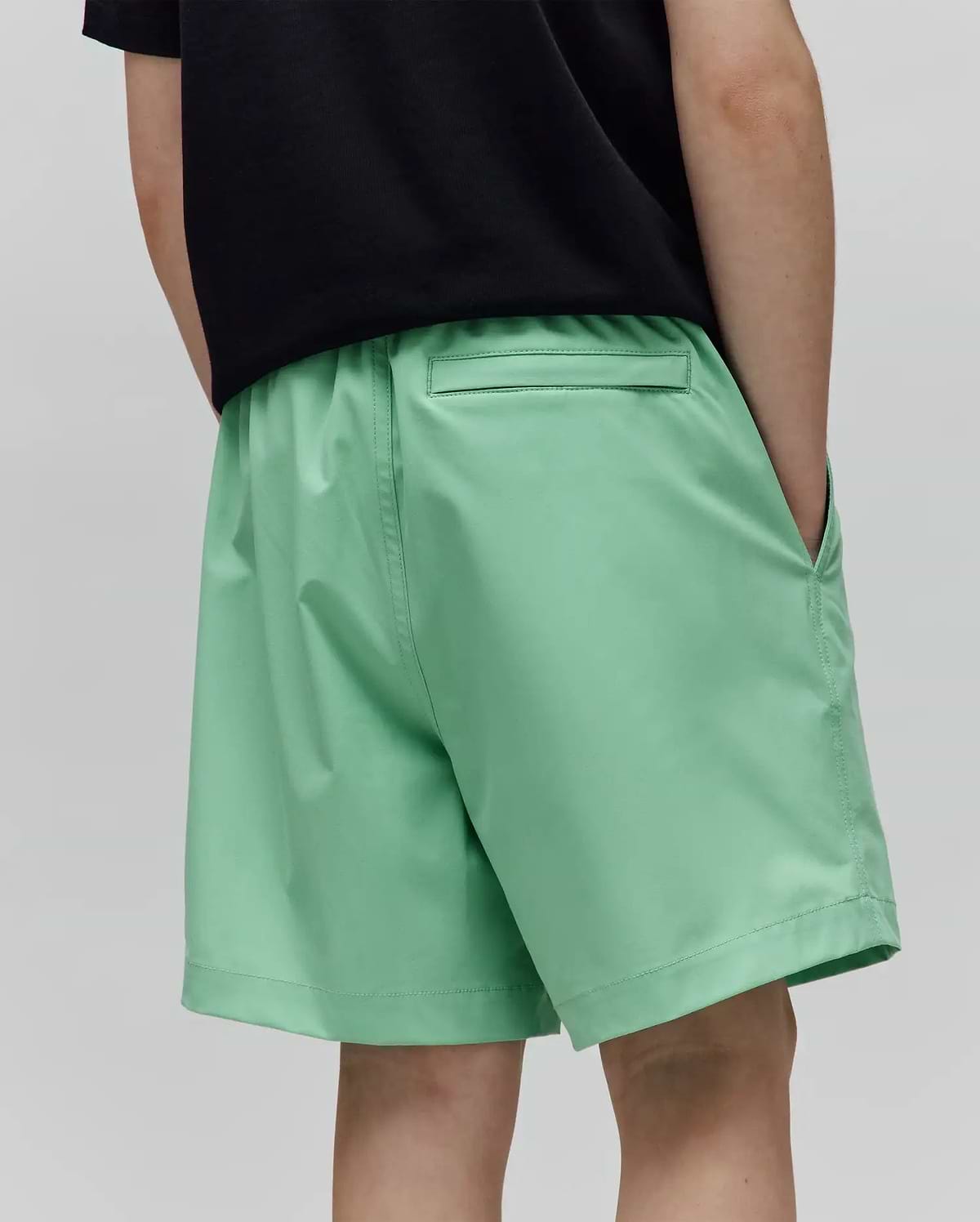 Kids Samos Hydrochromic Printed Swim Trunk in vibrant mint green, featuring a relaxed fit, smooth quick-dry fabric, elastic waistband, side pockets, and a back pocket, from Psycho Bunny.