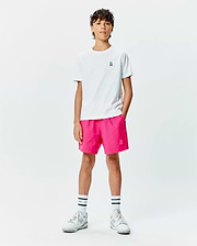 White classic-fit jersey t-shirt with small embroidered Psycho Bunny skull logo on chest, paired with hot pink Kids Samos Hydrochromic Printed Swim Trunk featuring a tonal embroidered bunny skull.