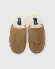 These men's suede slippers from Psycho Bunny feature a brown cow suede leather exterior and a plush white fleece lining. The embroidered rabbit skull and crossbones add a distinctive flair to the genuine shearling comfort they provide. (3)