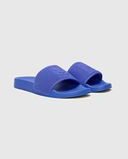 Mens Knit Slides in vibrant royal blue, showcasing a textured knitted strap with a prominent embossed Psycho Bunny skull logo, set on a smooth matching sole.