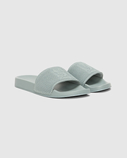 The Psycho Bunny MENS KNIT SLIDES - B6A474F200 are light green sandals with textured wide straps and an ergonomically molded footbed for comfort, shown on a plain white background.