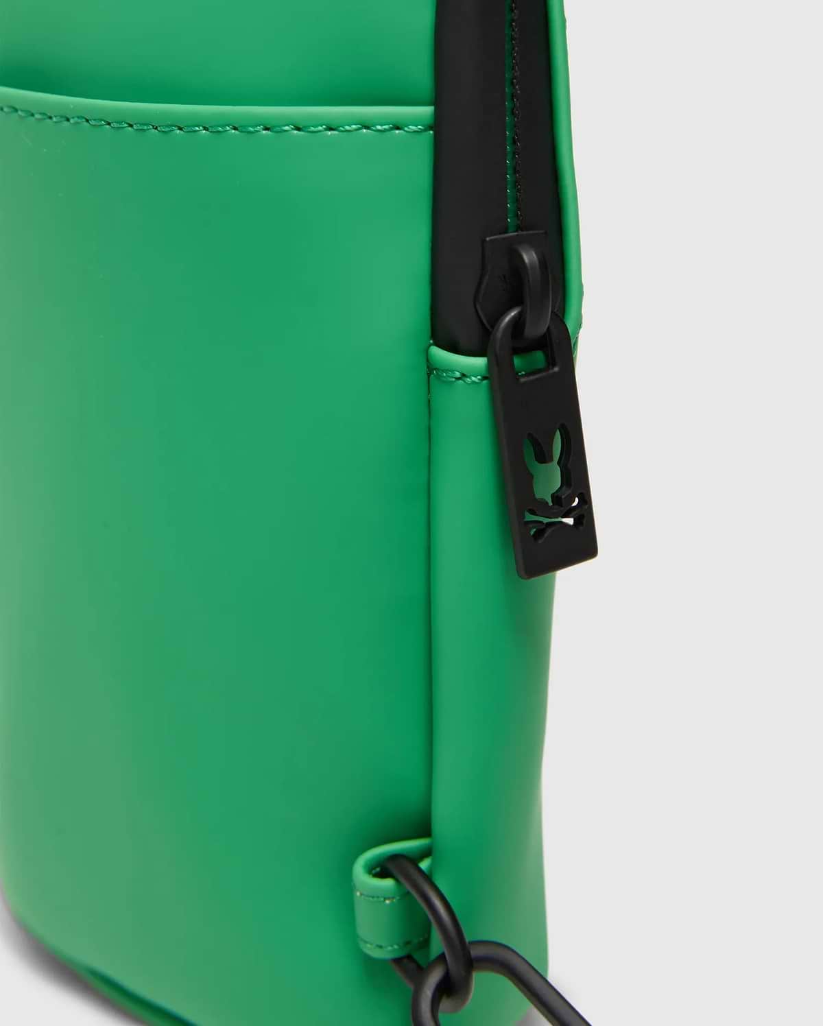 Mens Rubberized Crossbody in bright green with a smooth, rubberized finish, featuring a black zipper, hardware, and a small Psycho Bunny skull logo cutout on the zipper pull.