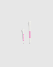 The image features two white tubes set against a light gray background, each with a pink label. The smaller tube is positioned on the left and is decorated with Psycho Bunny's 75 PACK GOLF TEES - B6A659C200, accented by bunny-themed designs. The larger tube is on the right, ideal for those looking for whimsical golf accessories from the Psycho Bunny brand.