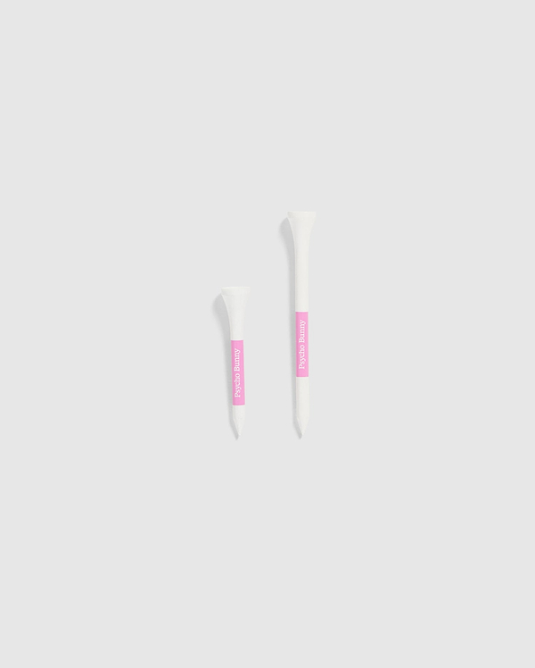 The image features two white tubes set against a light gray background, each with a pink label. The smaller tube is positioned on the left and is decorated with Psycho Bunny's 75 PACK GOLF TEES - B6A659C200, accented by bunny-themed designs. The larger tube is on the right, ideal for those looking for whimsical golf accessories from the Psycho Bunny brand.