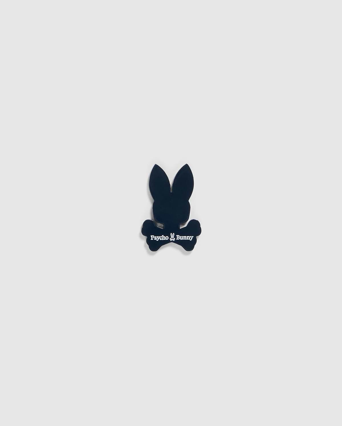 A small black silhouette of a bunny head with long ears and crossbones underneath, featuring the text "Psycho Bunny" in white below the head and above the crossbones, designed as an edgy BALL MARKER - B6A698C200 perfect for any golfer's collection by Psycho Bunny.