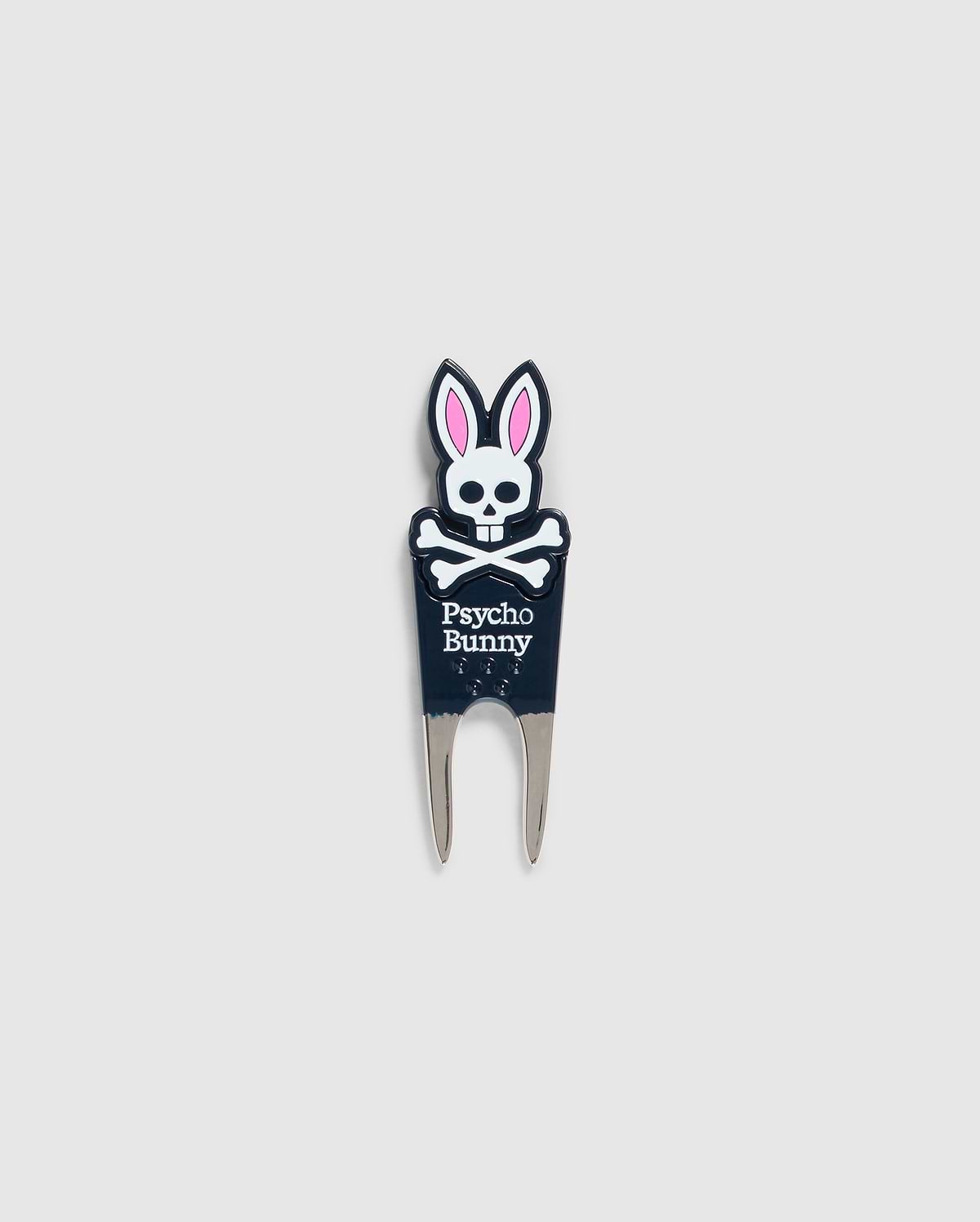 Image of a DIVOT TOOL - B6A699C200 from Psycho Bunny with a design featuring a skull with bunny ears and the text "Psycho Bunny" underneath. The tool has two prongs at the bottom, and the skull and ears are in black, white, and pink. A perfect addition to golf gifts, this tool also comes with a magnetic ball marker. The background is plain gray.