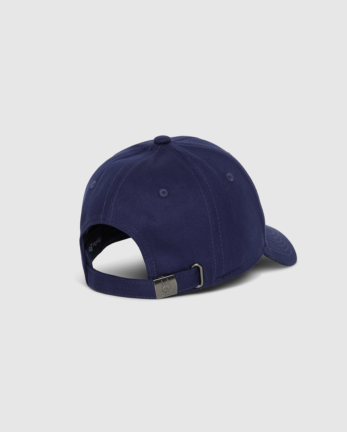 A rear view of the Psycho Bunny MENS CLASSIC BASEBALL CAP - B6A816A1HT in navy blue, featuring an adjustable strap with a metal buckle. Made from 100% cotton, this cap is set against a plain, light grey background.