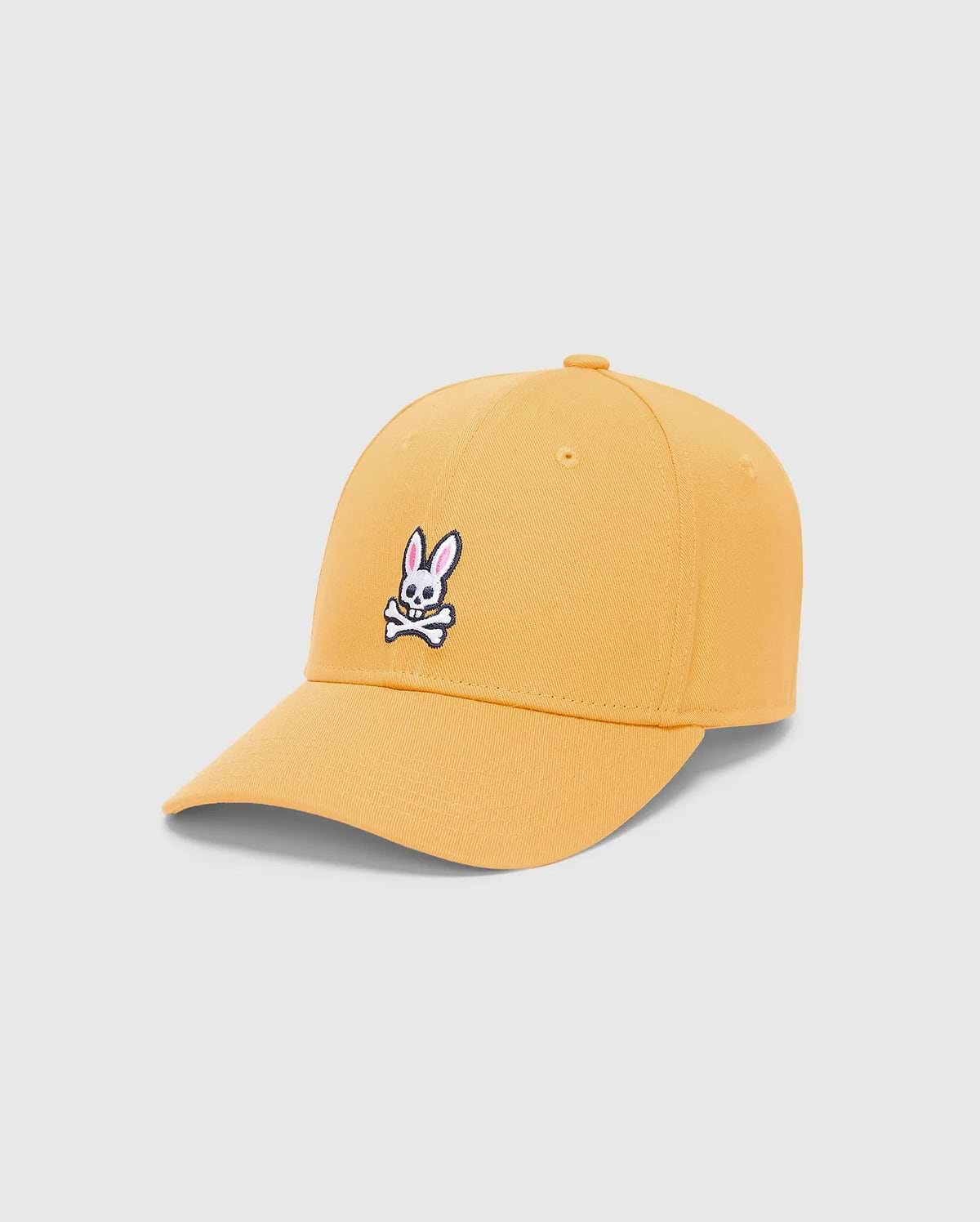Mens Classic Baseball Cap in vibrant mustard yellow twill, featuring a prominent embroidered white, black, and pink iconic Psycho Bunny skull logo centered on the front.