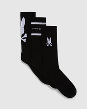 Displayed are three pairs of black sport socks from Psycho Bunny, known as the MENS 3 PACK SPORT SOCK - B6F997D200. Crafted from luxurious Peruvian pima cotton, each pair showcases a unique white design: one with a large bunny skull motif near the top, another featuring "PSYCHO BUNNY" text and horizontal stripes, and the last with a small bunny skull and crossbones near the top.