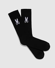 A pack of 3 pairs of black men's knee-high sport socks from the Psycho Bunny brand, featuring a white skull and crossbones symbol with bunny ears on each sock. Made from luxurious Peruvian pima cotton, these MENS 3 PACK SPORT SOCK - B6F997D200 socks are displayed positioned overlapping each other against a plain, light gray background.