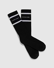 Introducing the MENS 3 PACK SPORT SOCK - B6F997D200 by Psycho Bunny: This pack includes 3 pairs of black crew sport socks, each adorned with white stripes near the top. Crafted from luxurious Peruvian pima cotton, these socks feature the "Psycho Bunny" text in white just below the stripes, all set against a plain light gray backdrop.