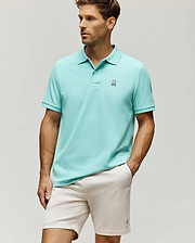 Mens Classic Pique Polo in aqua, a classic fit pique knit with a two-button placket, ribbed collar and cuffs, and a small embroidered white, black, and pink Psycho Bunny skull logo on the left chest.