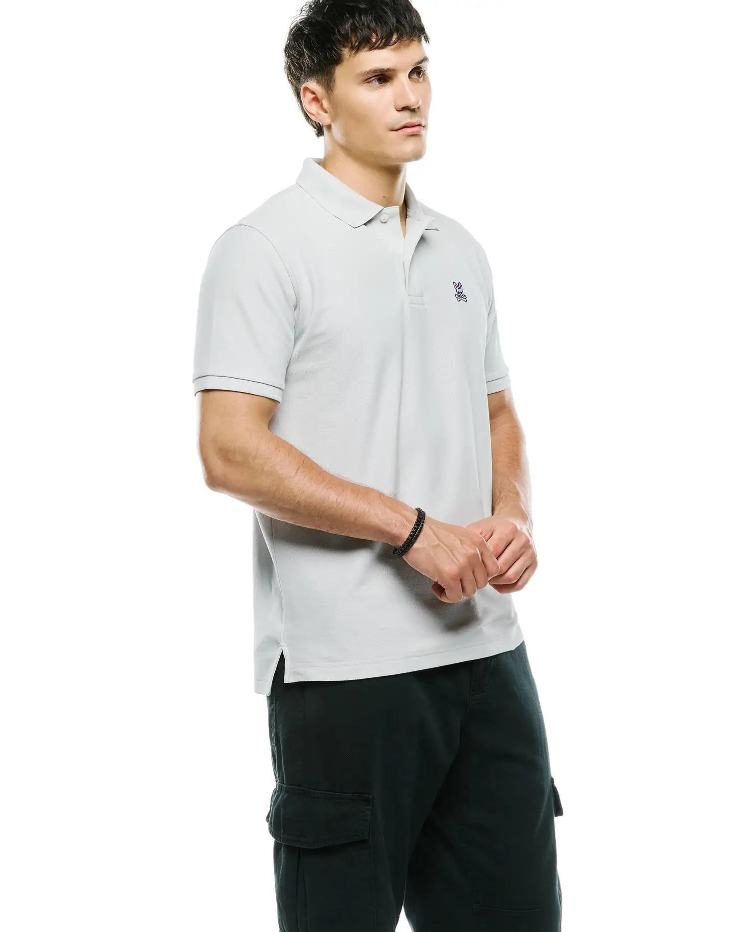 MENS CLASSIC PIQUE POLO in light grey, featuring a classic fit and pique texture. Small multi-color embroidered Psycho Bunny skull logo on the left chest, with ribbed collar and cuffs.
