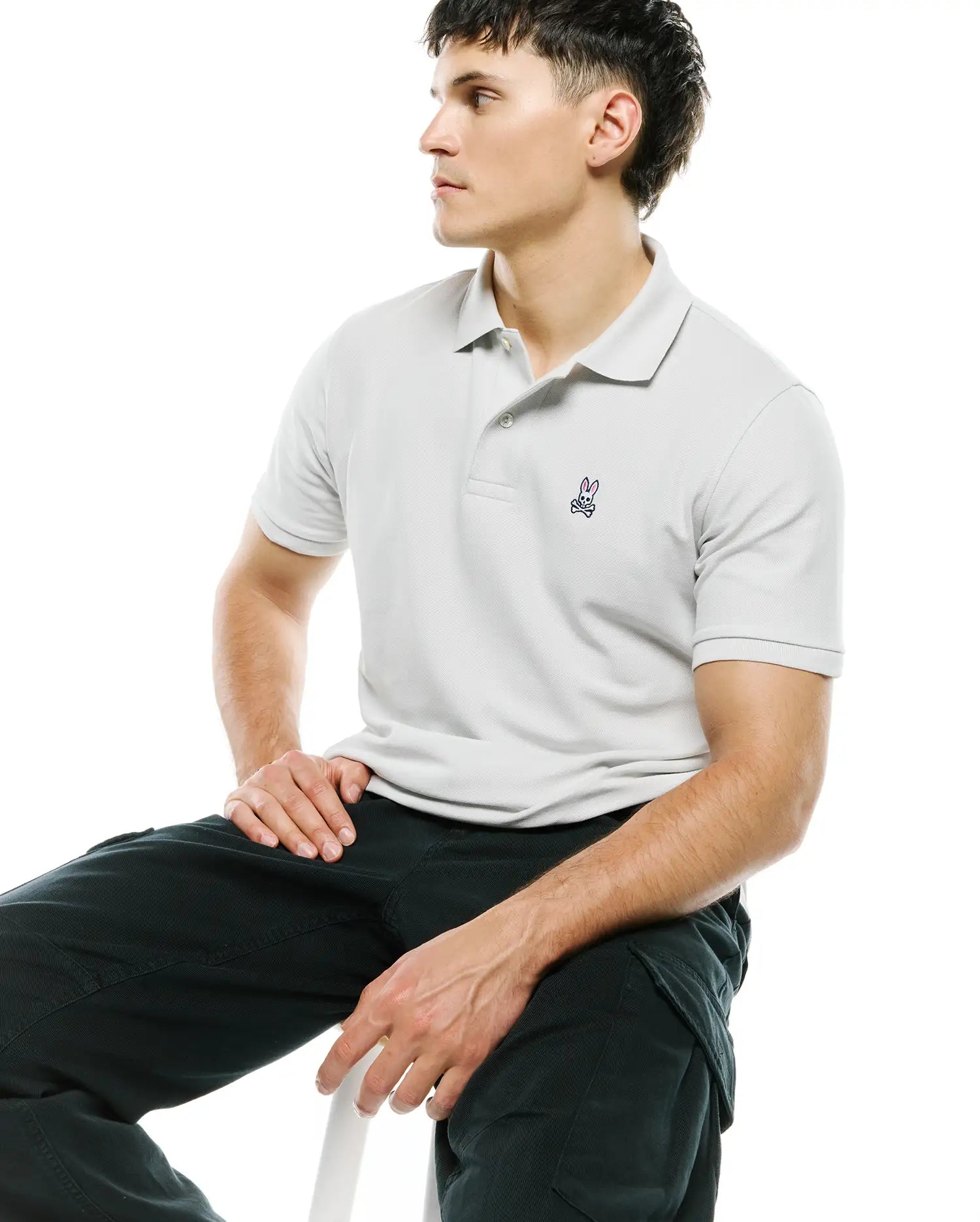 Mens Classic Pique Polo in light grey, featuring a classic fit and a small, embroidered Psycho Bunny skull logo on the left chest with navy and pink accents.