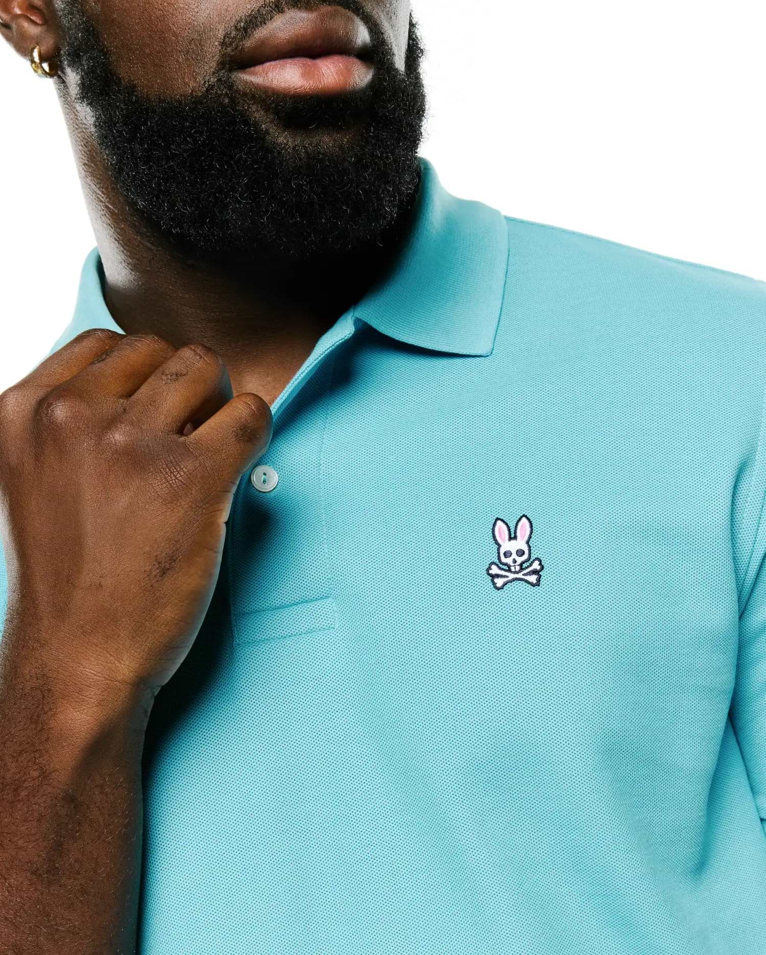 Men's Classic Pima Pique Polo in vibrant aqua, featuring a classic fit, textured pique fabric, and a small embroidered Psycho Bunny skull and crossbones logo with pink ears on the left chest. (3)