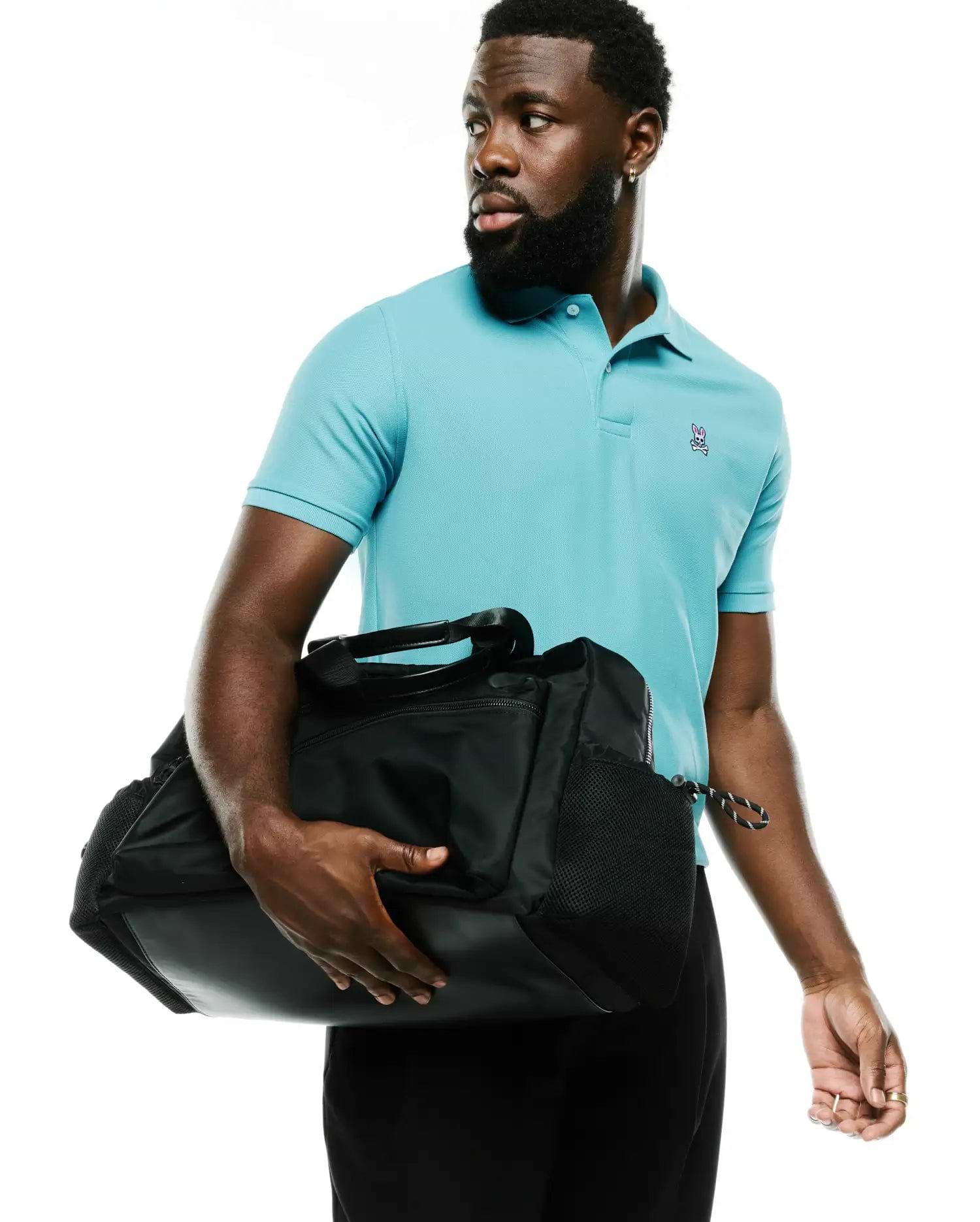 Men's Classic Pima Pique Polo in vibrant aqua blue, featuring a classic fit and a small, embroidered pink, white, and black Psycho Bunny skull logo on the left chest. (4)