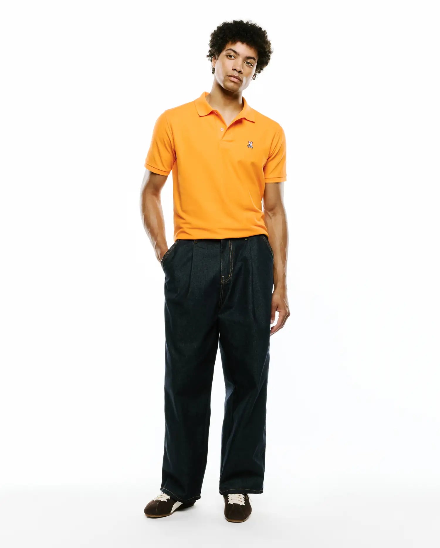 Mens Classic Pique Polo in vibrant orange, featuring a classic fit, textured pique fabric, and a small embroidered Psycho Bunny skull logo on the left chest.
