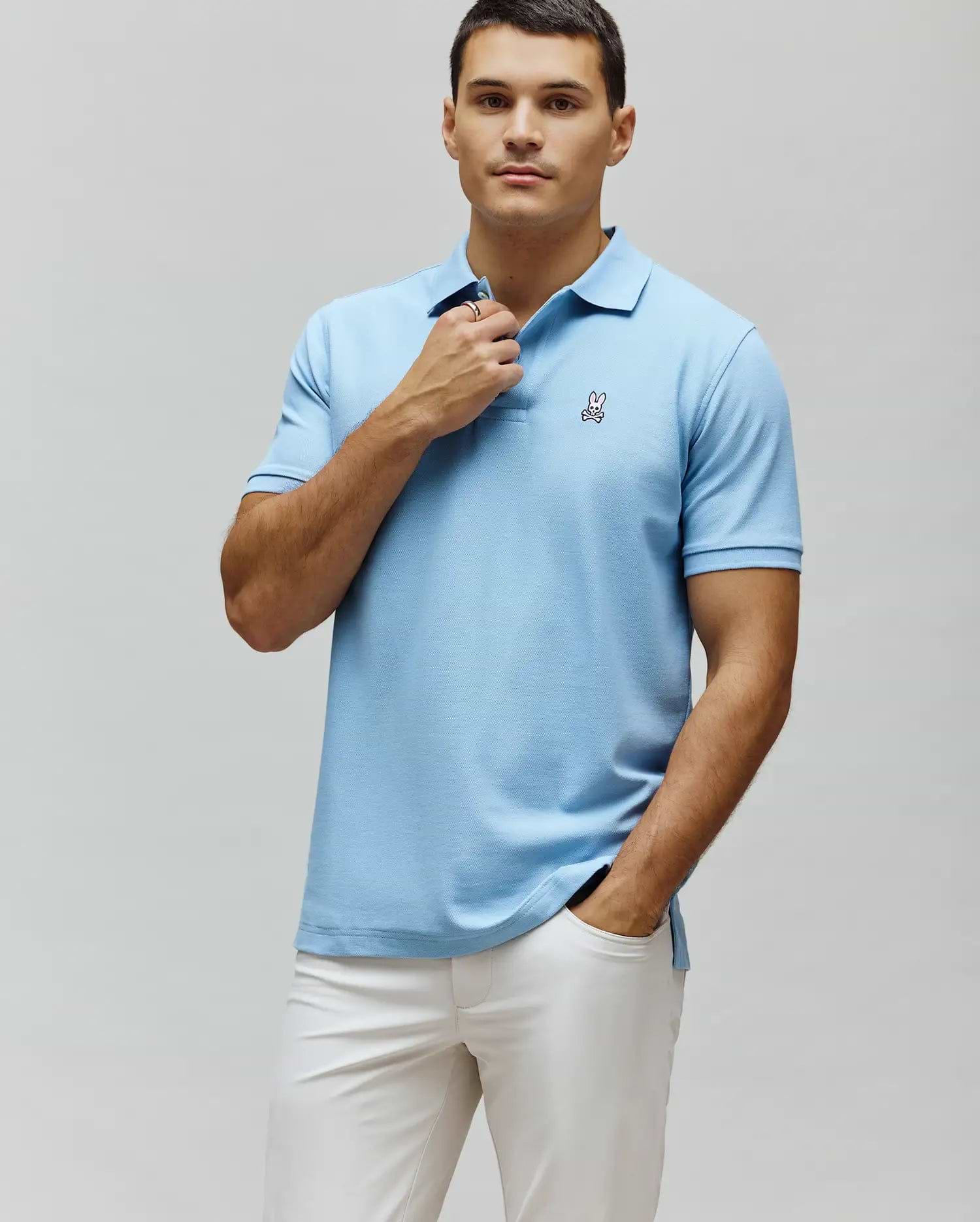 Mens Classic Pique Polo, light blue, classic fit, pique knit fabric, featuring a small embroidered pink and white Psycho Bunny skull logo on the left chest.