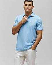 Mens Classic Pique Polo, light blue, classic fit, pique knit fabric, featuring a small embroidered pink and white Psycho Bunny skull logo on the left chest.