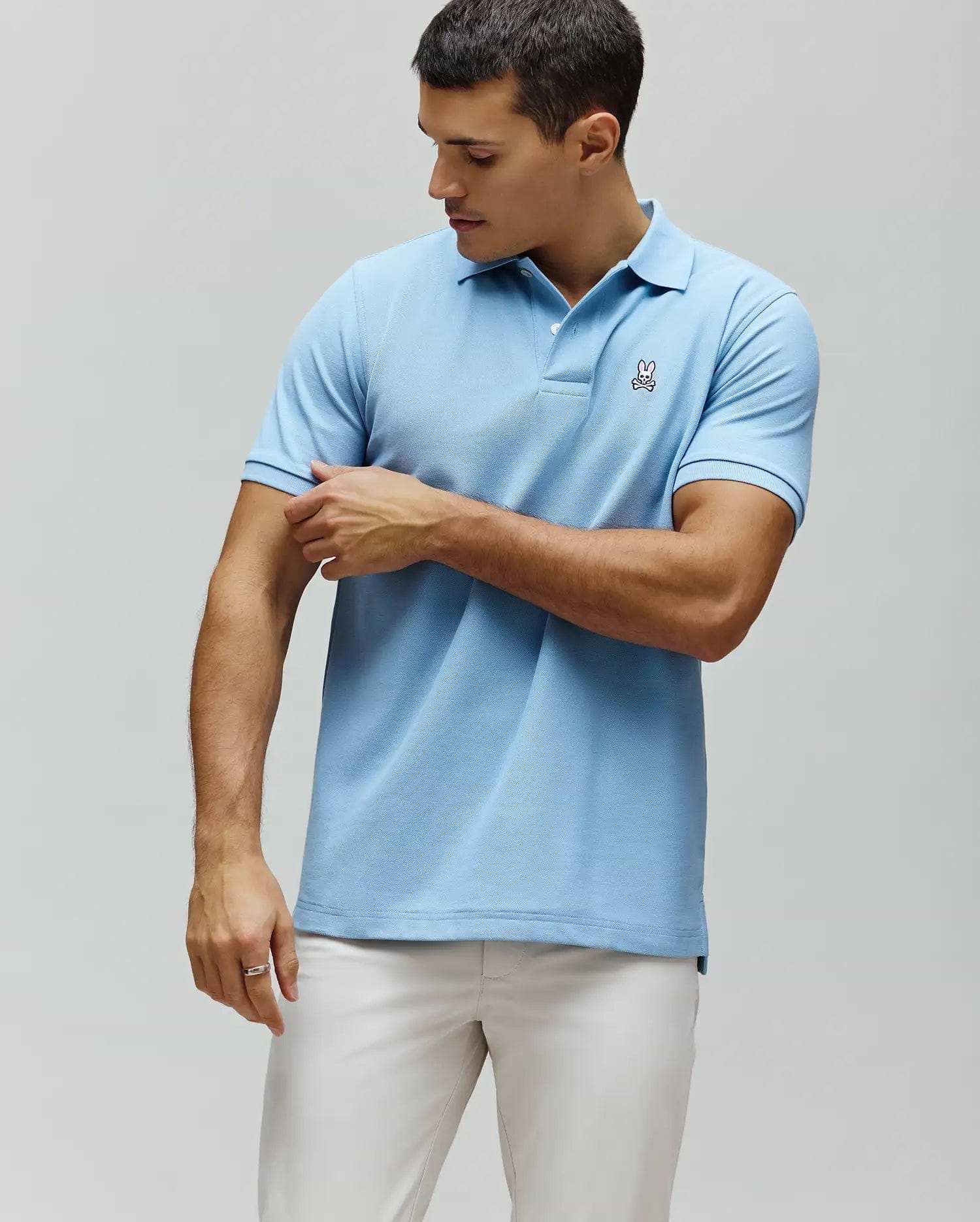 Mens Classic Pique Polo, light blue classic fit pique knit with a two-button placket and a small embroidered Psycho Bunny skull logo on the left chest.