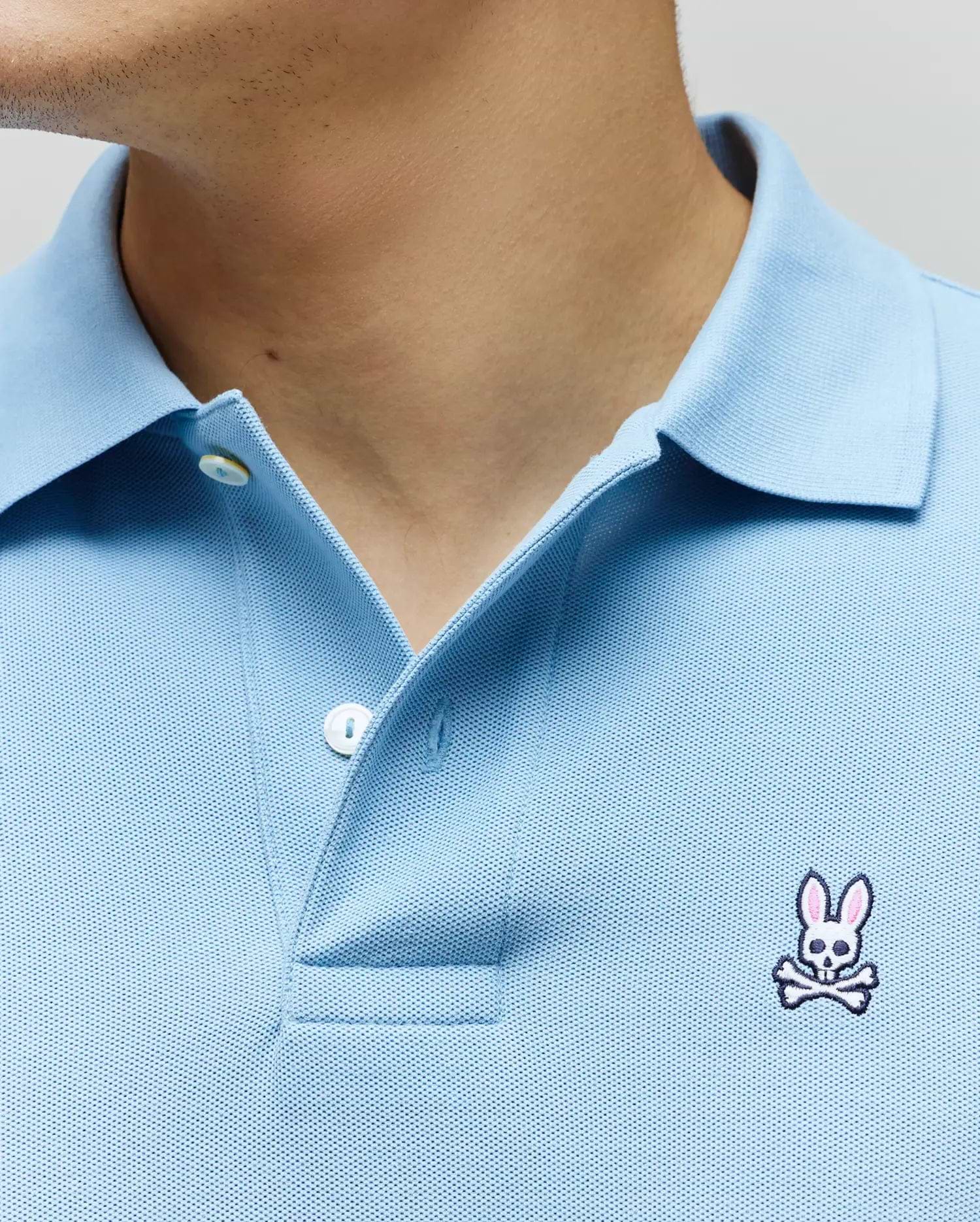 Light blue Mens Classic Pique Polo with a classic fit, pique knit texture, two-button placket, and a small embroidered white, pink, and black Psycho Bunny skull logo on the left chest.