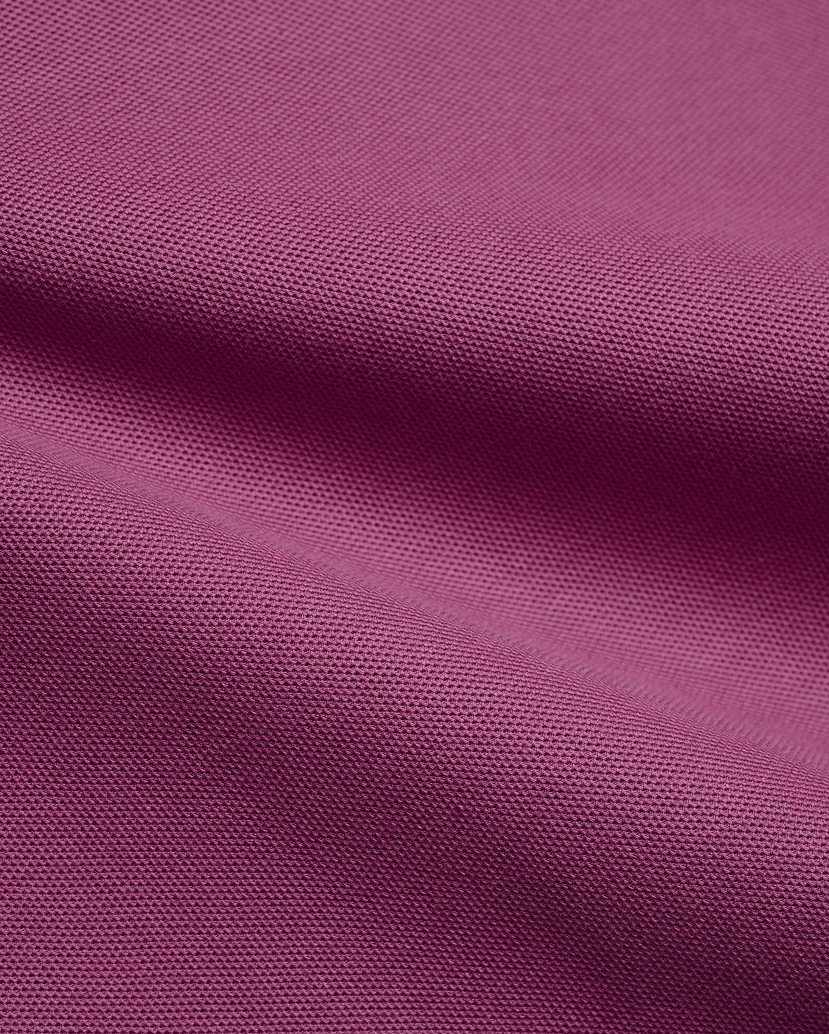 Psycho Bunny Mens Classic Pique Polo fabric in a vibrant deep magenta, highlighting the premium, breathable pique knit texture with elegant, soft folds, perfect for refined streetwear.